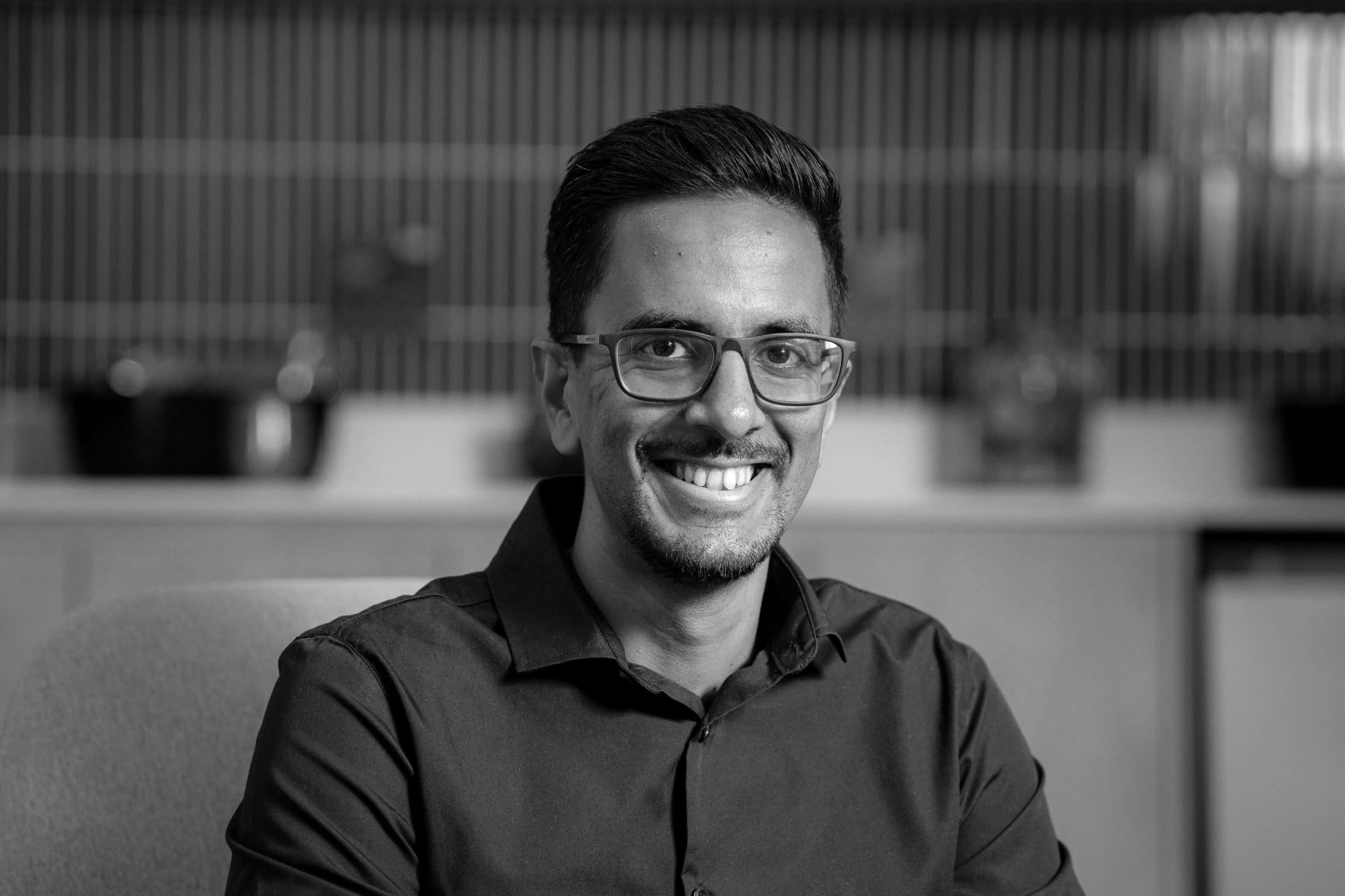 Vishen seated and staring at the camera with a smile