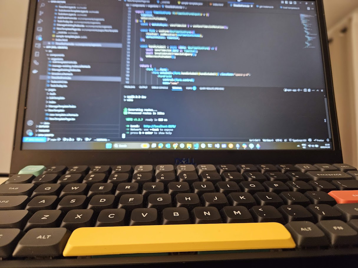 Laptop with code editor open in background